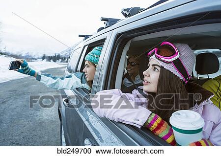 Friends photographing from car in winter View Large Photo Image Stock Image - Friends photographing from car in winter. Fotosearch