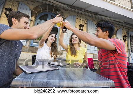 Stock Image - Friends toasting at restaurant. Fotosearch