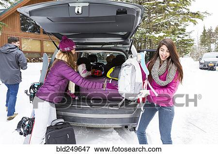 Friends unloading car at winter resort View Large Photo Image Stock Photo - Friends unloading car at winter resort. Fotosearch