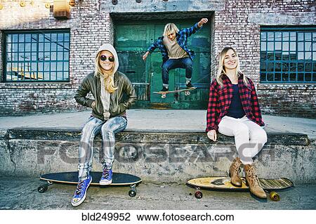 Friends with skateboards smiling on loading dock View Large Photo Image Stock Image - Friends with skateboards smiling on loading dock. Fotosearch