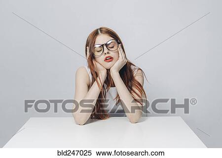 Stock Photography - Frustrated Caucasian woman sitting at table. Fotosearch