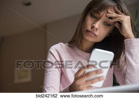 Frustrated Mixed Race woman texting on cell phone View Large Photo Image Stock Image - Frustrated Mixed Race woman texting on cell phone. Fotosearch