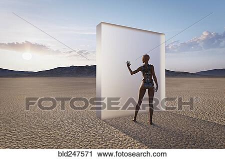 Stock Image - Futuristic woman touching glass wall in desert. Fotosearch