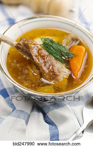 Stock Image - Garnish on bowl of soup with meat. Fotosearch