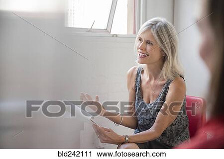 Gesturing Caucasian businesswoman with notepad talking in meeting View Large Photo Image Stock Image - Gesturing Caucasian businesswoman with notepad talking in meeting. Fotosearch