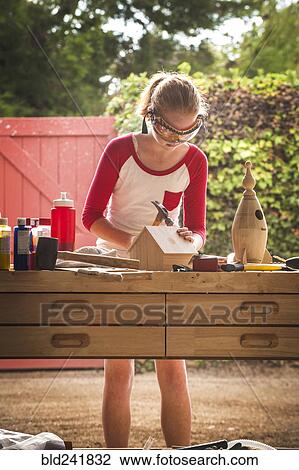 Girl hammering, building birdhouse in garage View Large Photo Image Stock Image - Girl hammering, building birdhouse in garage. Fotosearch
