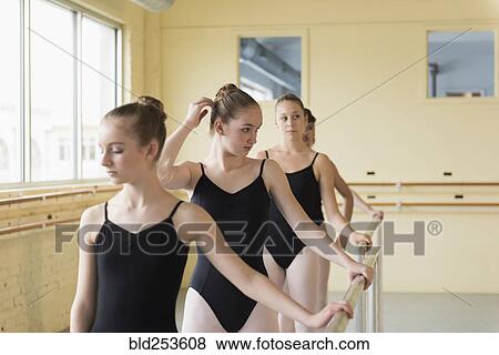 Stock Photo - Girls holding barre in ballet studio. Fotosearch