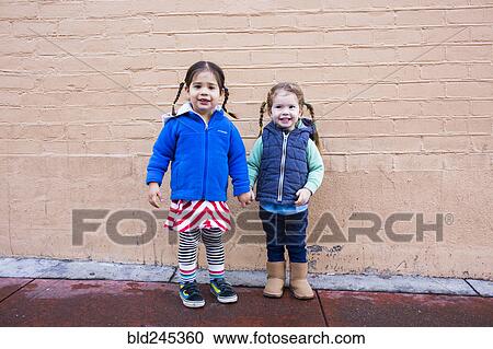Girls holding hands on sidewalk View Large Photo Image Stock Image - Girls holding hands on sidewalk. Fotosearch