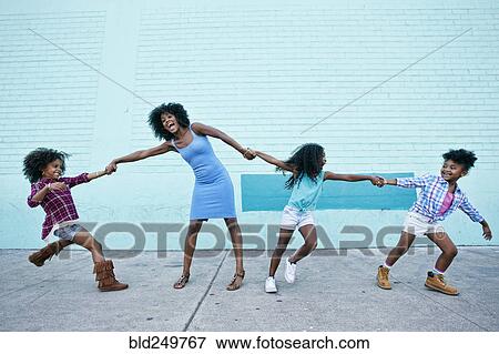 Stock Photo - Girls pulling arms of woman in opposite directions. Fotosearch