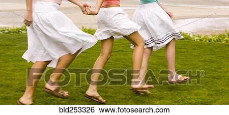 Stock Photograph - Girls walking and holding hands. Fotosearch