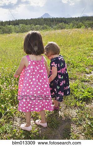 Stock Photo - Girls walking together in field. Fotosearch
