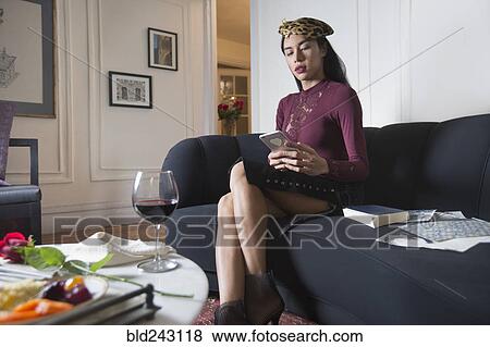 Stock Photo - Glamorous transgender Thai woman texting on cell phone. Fotosearch