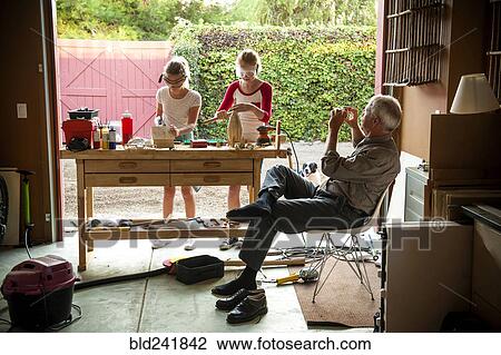 Grandfather photographing granddaughters building birdhouse in garage View Large Photo Image Stock Image - Grandfather photographing granddaughters building birdhouse in garage. Fotosearch