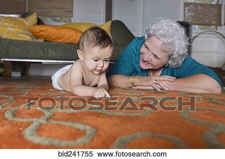 Stock Photography - Grandmother and grandson laying on carpet. Fotosearch