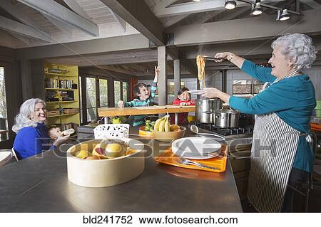 Stock Image - Grandmothers and grandchildren having fun in kitchen. Fotosearch