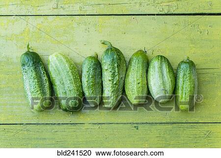 Green cucumbers in a row on wooden table View Large Photo Image Stock Image - Green cucumbers in a row on wooden table. Fotosearch