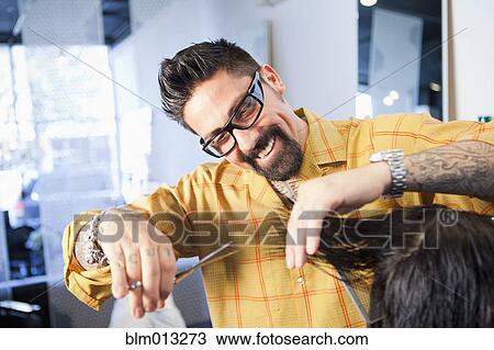 Stock Image - Hairdresser cutting hair in salon. Fotosearch