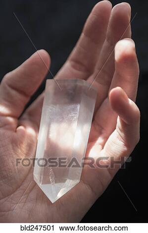 Stock Image - Hand of Caucasian woman holding crystal. Fotosearch