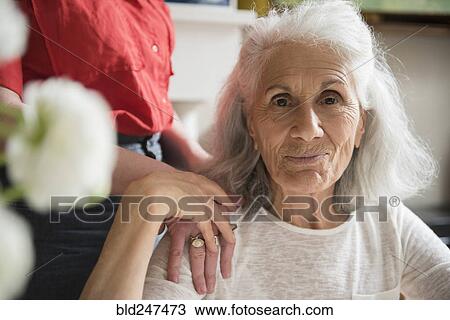 Stock Image - Hand of daughter on shoulder of older mother. Fotosearch