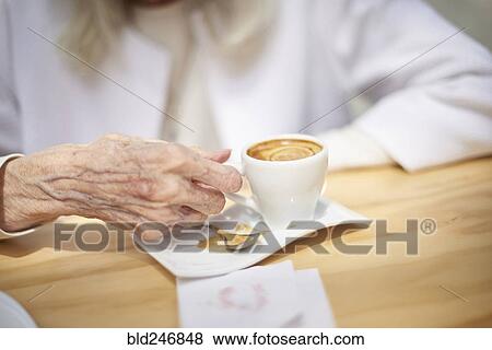 Stock Photo - Hand of older Caucasian woman drinking coffee. Fotosearch