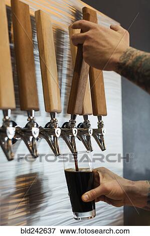 Hands of Caucasian man pouring beer from tap View Large Photo Image Stock Photo - Hands of Caucasian man pouring beer from tap. Fotosearch