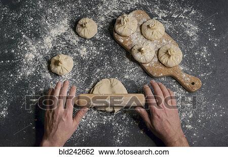 Hands of Caucasian man using rolling pin on dough View Large Photo Image Stock Image - Hands of Caucasian man using rolling pin on dough. Fotosearch