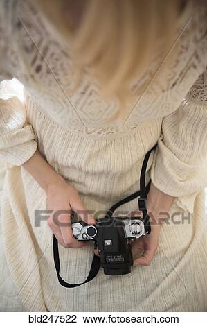 Hands of Caucasian woman holding camera in lap View Large Photo Image Stock Image - Hands of Caucasian woman holding camera in lap. Fotosearch