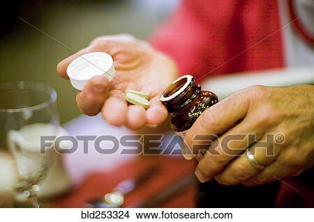 Picture - Hands of Caucasian woman holding supplements. Fotosearch