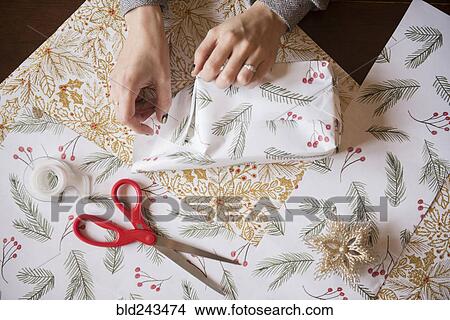 Hands of Caucasian woman wrapping Christmas gifts View Large Photo Image Picture - Hands of Caucasian woman wrapping Christmas gifts. Fotosearch