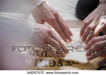 Hands of Caucasian women using a Ouija board View Large Photo Image Stock Image - Hands of Caucasian women using a Ouija board. Fotosearch