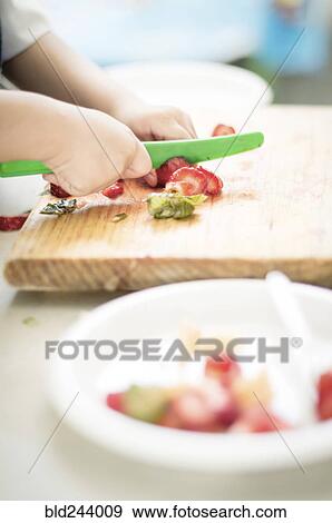 Hands of Hispanic boy cutting strawberry with plastic knife View Large Photo Image Stock Photo - Hands of Hispanic boy cutting strawberry with plastic knife. Fotosearch