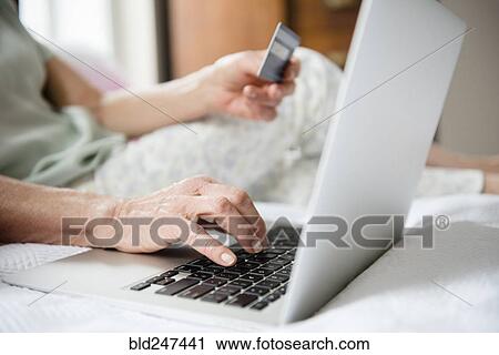 Hands of older woman shopping online with credit card and laptop View Large Photo Image Stock Image - Hands of older woman shopping online with credit card and laptop. Fotosearch