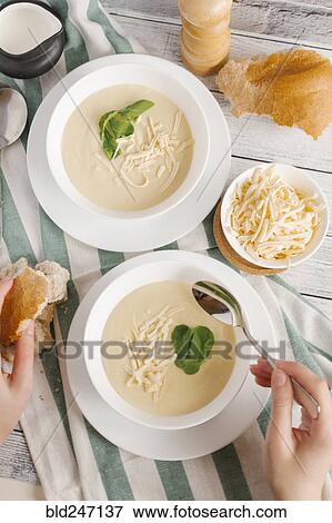 Hands of woman eating bowl of cheese soup View Large Photo Image Stock Photo - Hands of woman eating bowl of cheese soup. Fotosearch