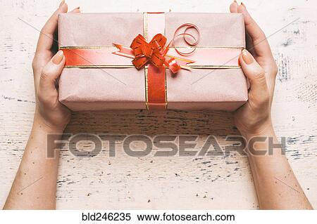 Stock Photography - Hands of woman holding gift box. Fotosearch
