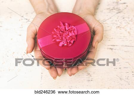 Hands of woman holding round gift box View Large Photo Image Stock Photograph - Hands of woman holding round gift box. Fotosearch