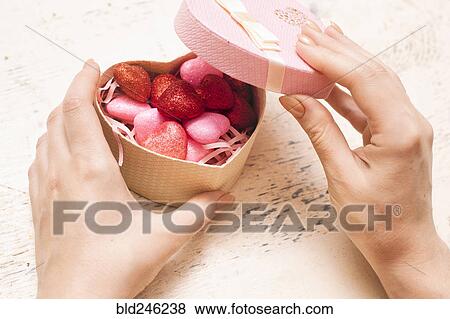 Stock Photo - Hands of woman opening valentine gift box. Fotosearch