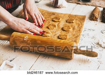 Stock Photo - Hands of woman pressing cookie dough on baking sheet. Fotosearch
