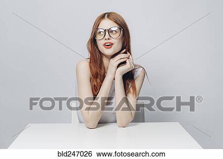 Happy Caucasian woman sitting at table View Large Photo Image Stock Photograph - Happy Caucasian woman sitting at table. Fotosearch