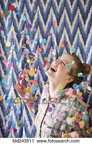 Stock Image - Happy woman celebrating with confetti. Fotosearch