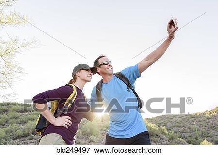 Stock Photo - Hikers posing for cell phone selfie. Fotosearch