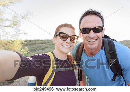 Stock Photograph - Hikers posing for cell phone selfie. Fotosearch