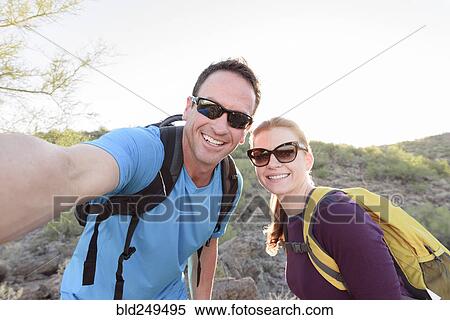 Stock Photography - Hikers posing for cell phone selfie. Fotosearch