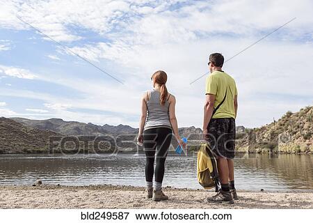 Stock Photo - Hikers resting at lake. Fotosearch