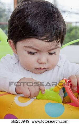 Stock Photo - Hispanic baby boy playing with toy. Fotosearch