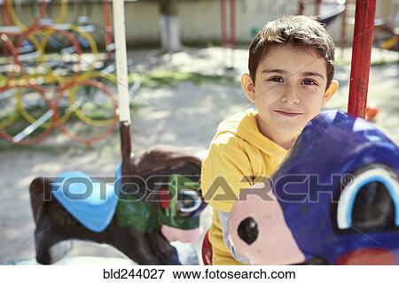 Hispanic boy on carousel at playground View Large Photo Image Stock Photo - Hispanic boy on carousel at playground. Fotosearch