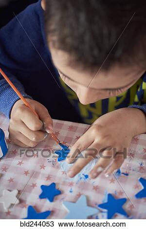 Hispanic boy painting stars at table View Large Photo Image Stock Image - Hispanic boy painting stars at table. Fotosearch