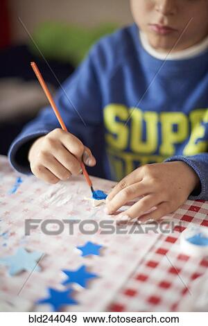 Hispanic boy painting stars at table View Large Photo Image Stock Photo - Hispanic boy painting stars at table. Fotosearch