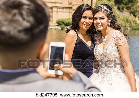 Stock Photography - Hispanic boy photographing girls with cell phone. Fotosearch