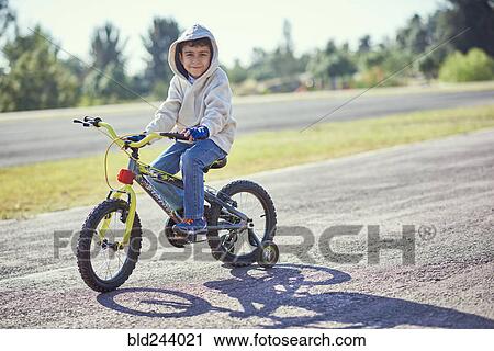 Hispanic boy posing on bicycle with training wheels View Large Photo Image Stock Image - Hispanic boy posing on bicycle with training wheels. Fotosearch