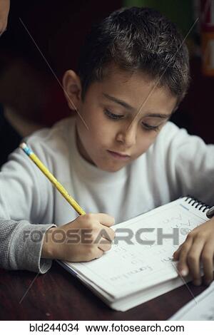 Picture - Hispanic boy practicing writing alphabet. Fotosearch